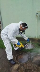 Técnico da Bytek aplicando nebulização em bueiro para controle de pragas