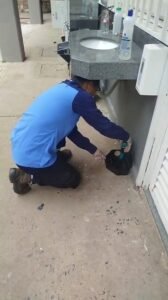 Técnico da Bytek instalando isca em caixa de gordura