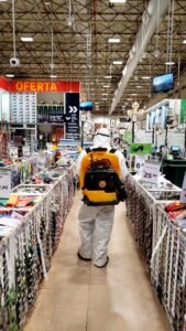 Técnico da Bytek com pulverizador costal realizando aplicação em loja